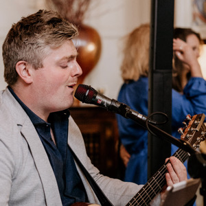 playing guitar and singing at event